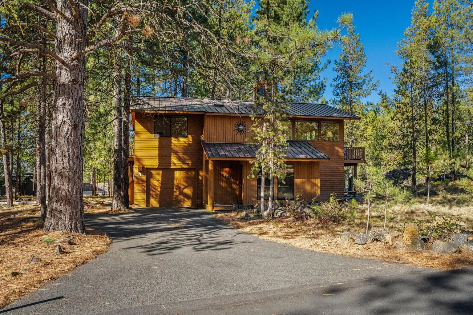 Front of home welcomes you with long asphalt driveway.