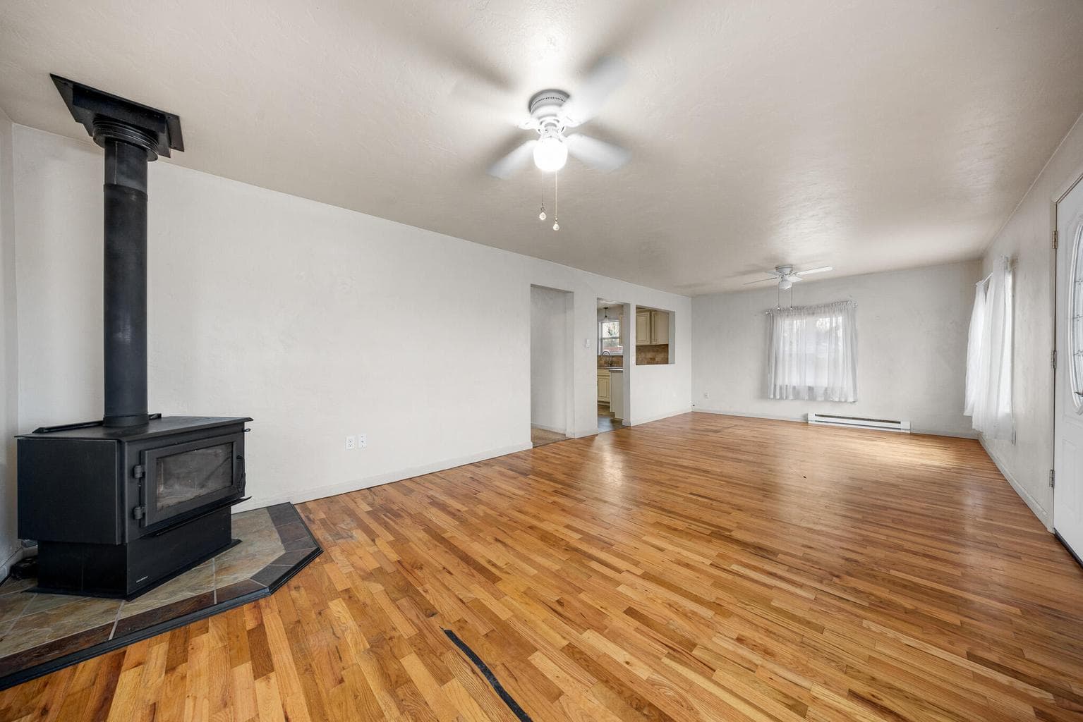 Living room has wood floors, wood stove, lots of windows with views of the cascades.