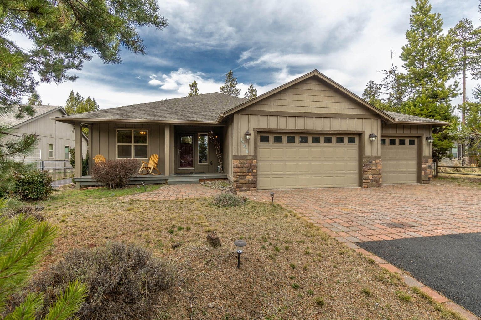 Covered front porch, paver driveway and large triple car garage.