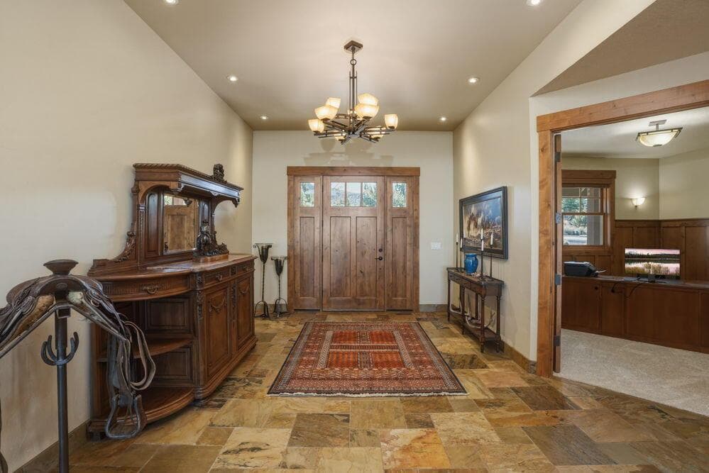 Tiled grand foyer leads to office, great room, primary bedroom, and hallway to stairs