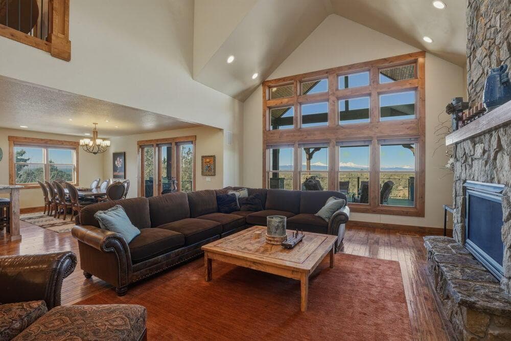 Great room features vaulted ceilings, great windows to capture the mountain views, floor-to-ceiling stone fireplace