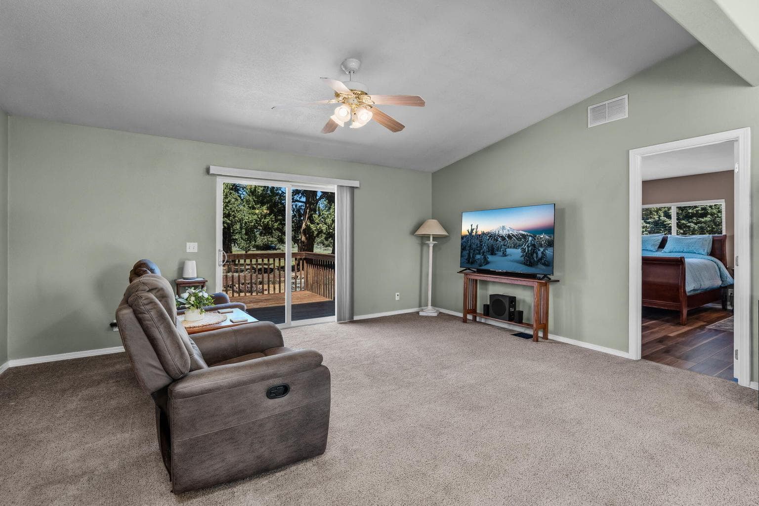Living room with deck access, adjoins primary bedroom and kitchen area
