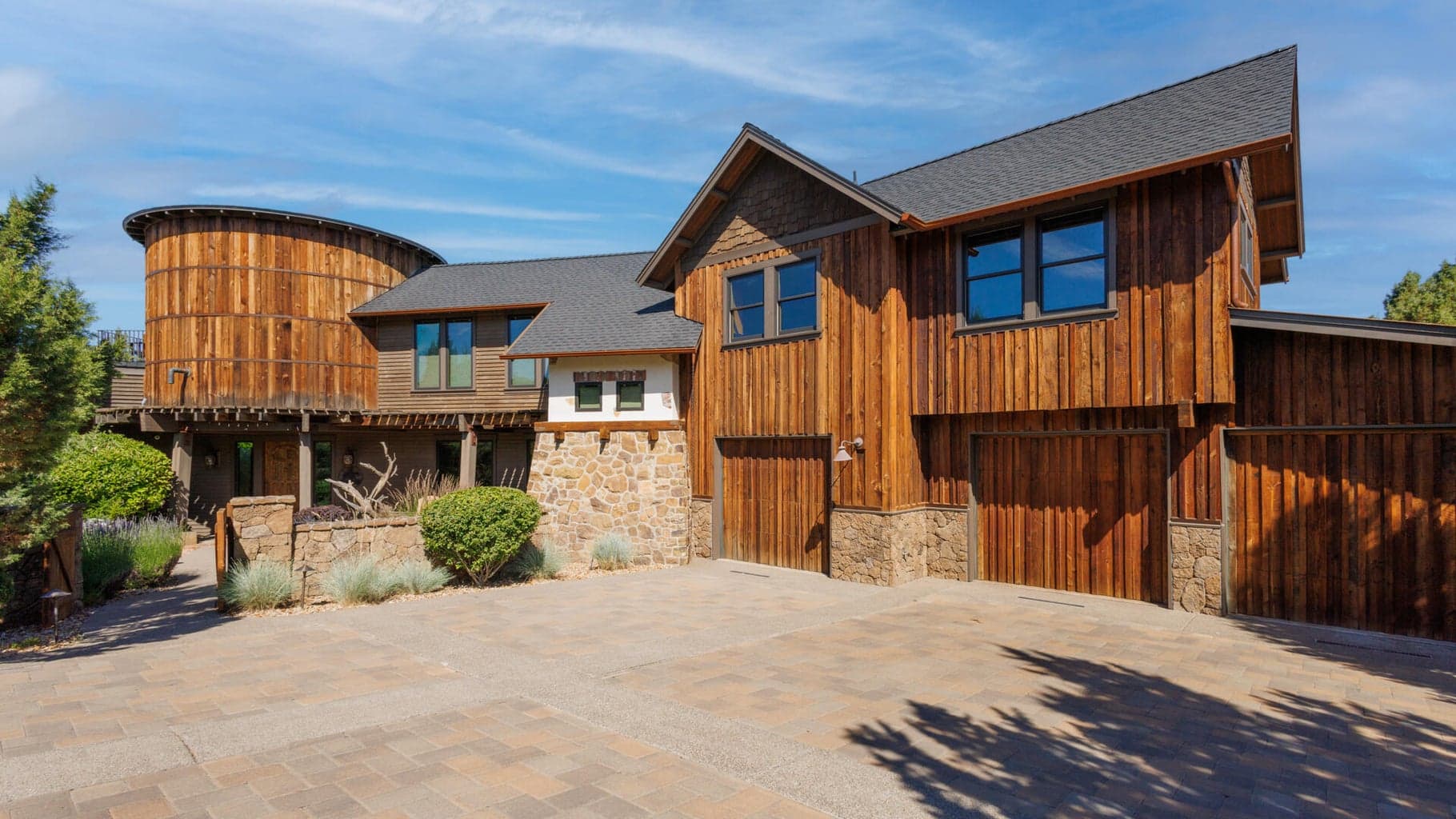Unique estate design with a water tower feature, covered patio, gate and garage