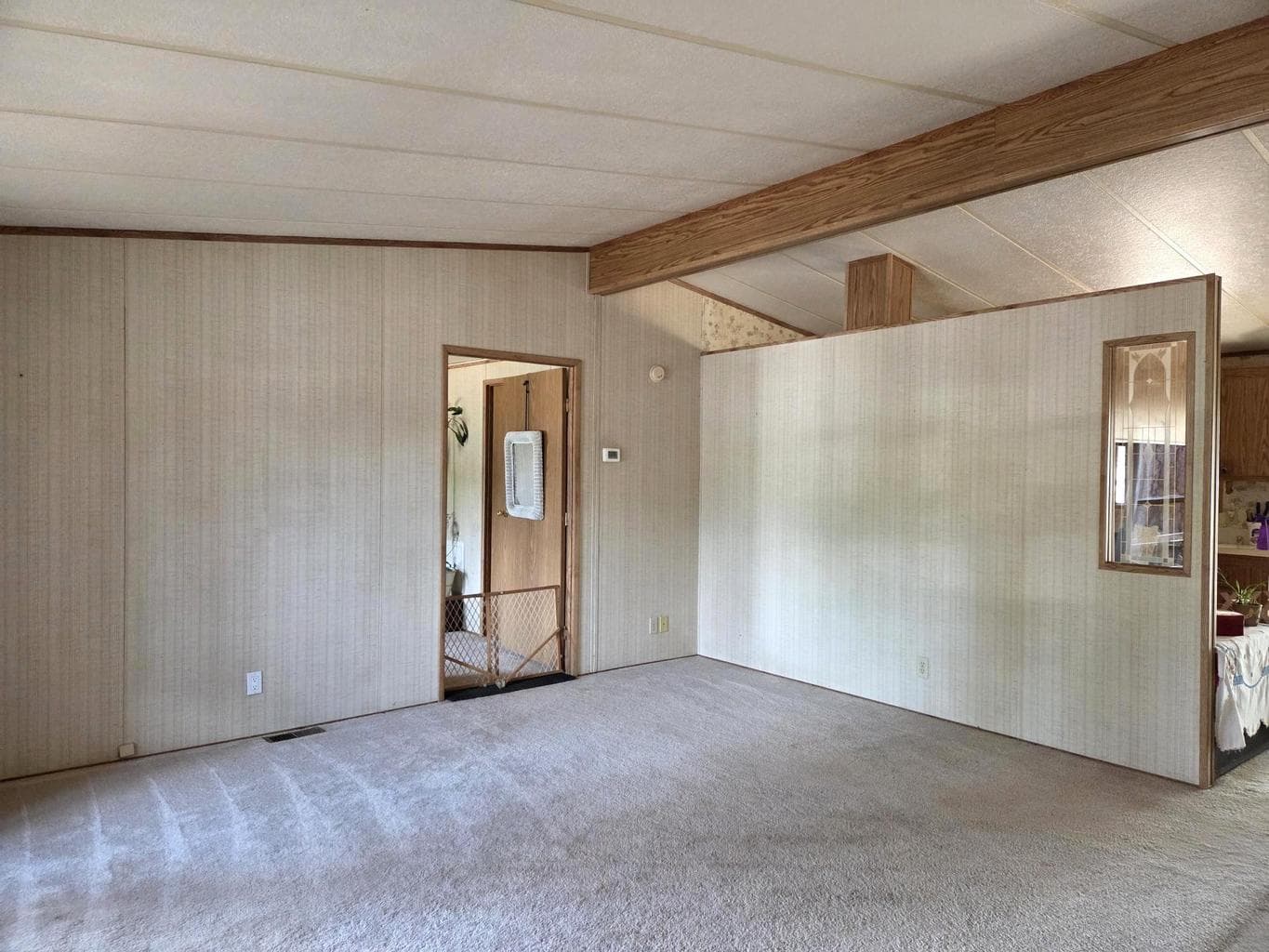 Living room has vaulted ceilings and beam.