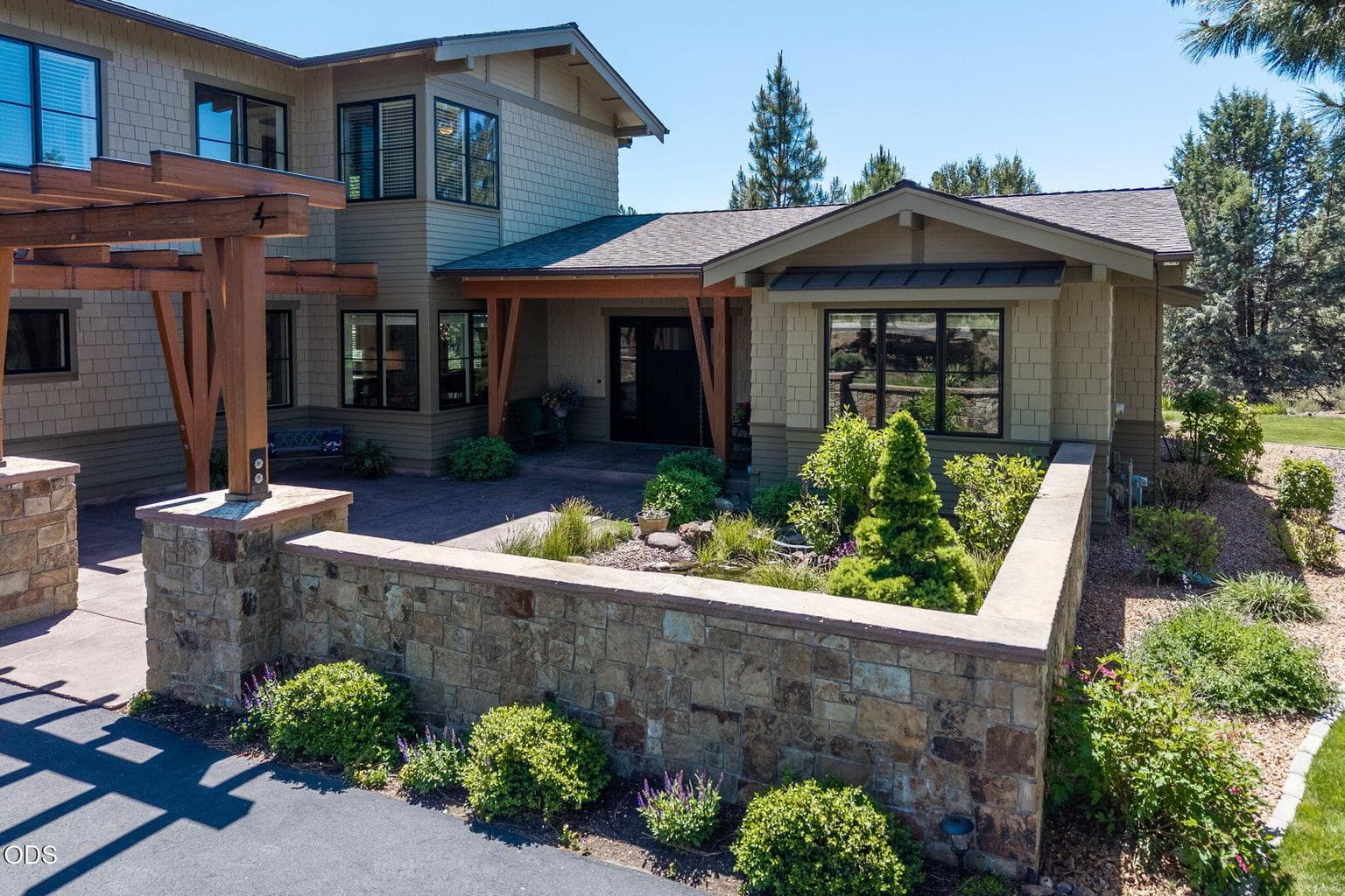 A warm covered entry with timber accents, custom door detail, and generous seating space creates an inviting arrival.