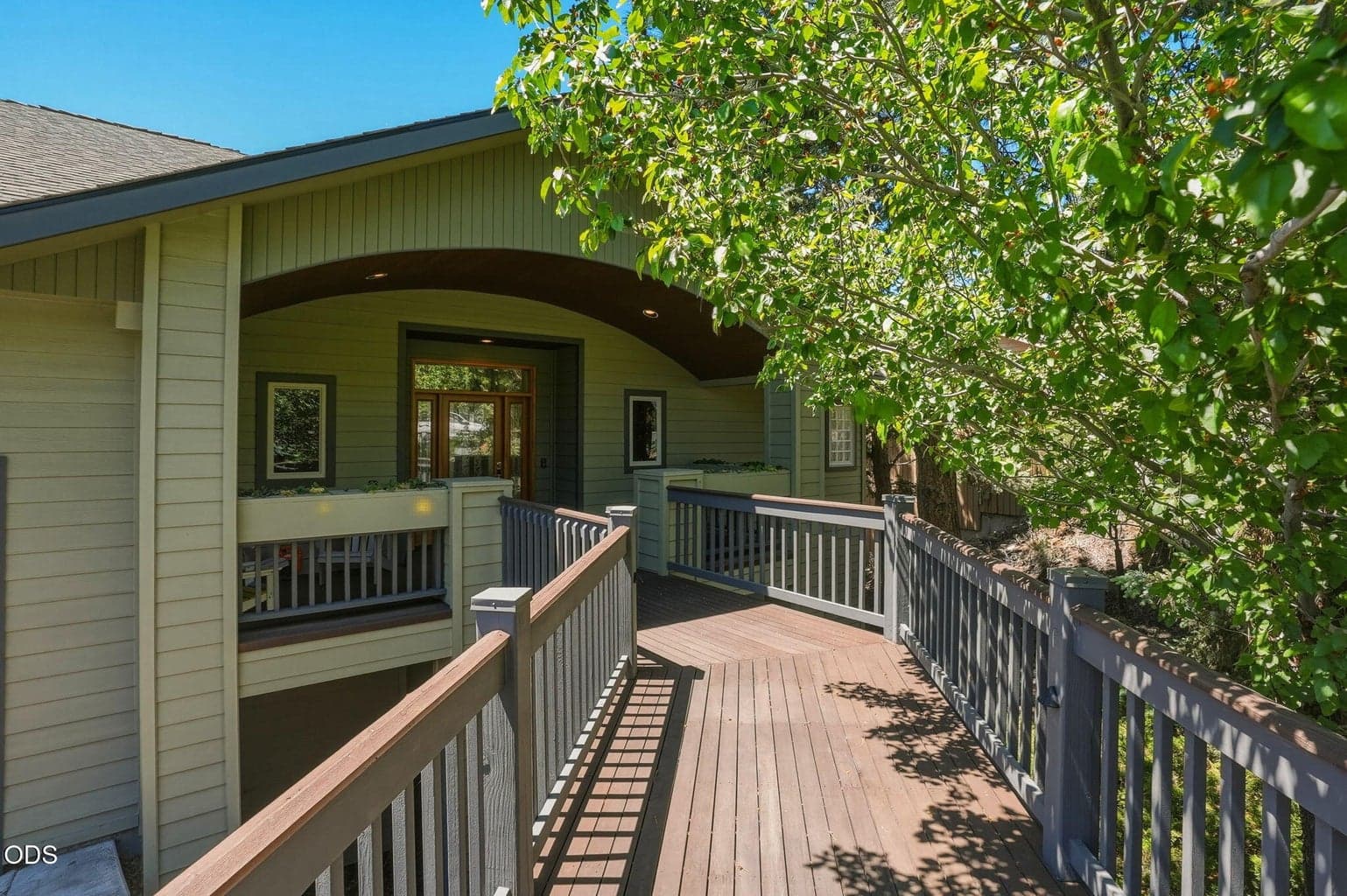 A canopy of blooming trees enhances the home's curb appeal and warmly welcomes guests to the covered front entry