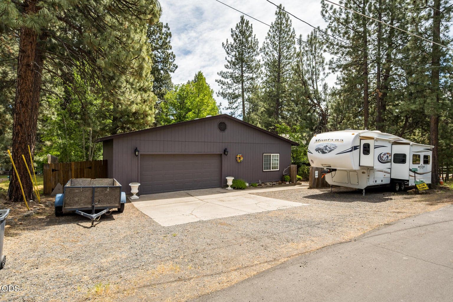 RV parking in the front. Home is nestled behind the detached garage.