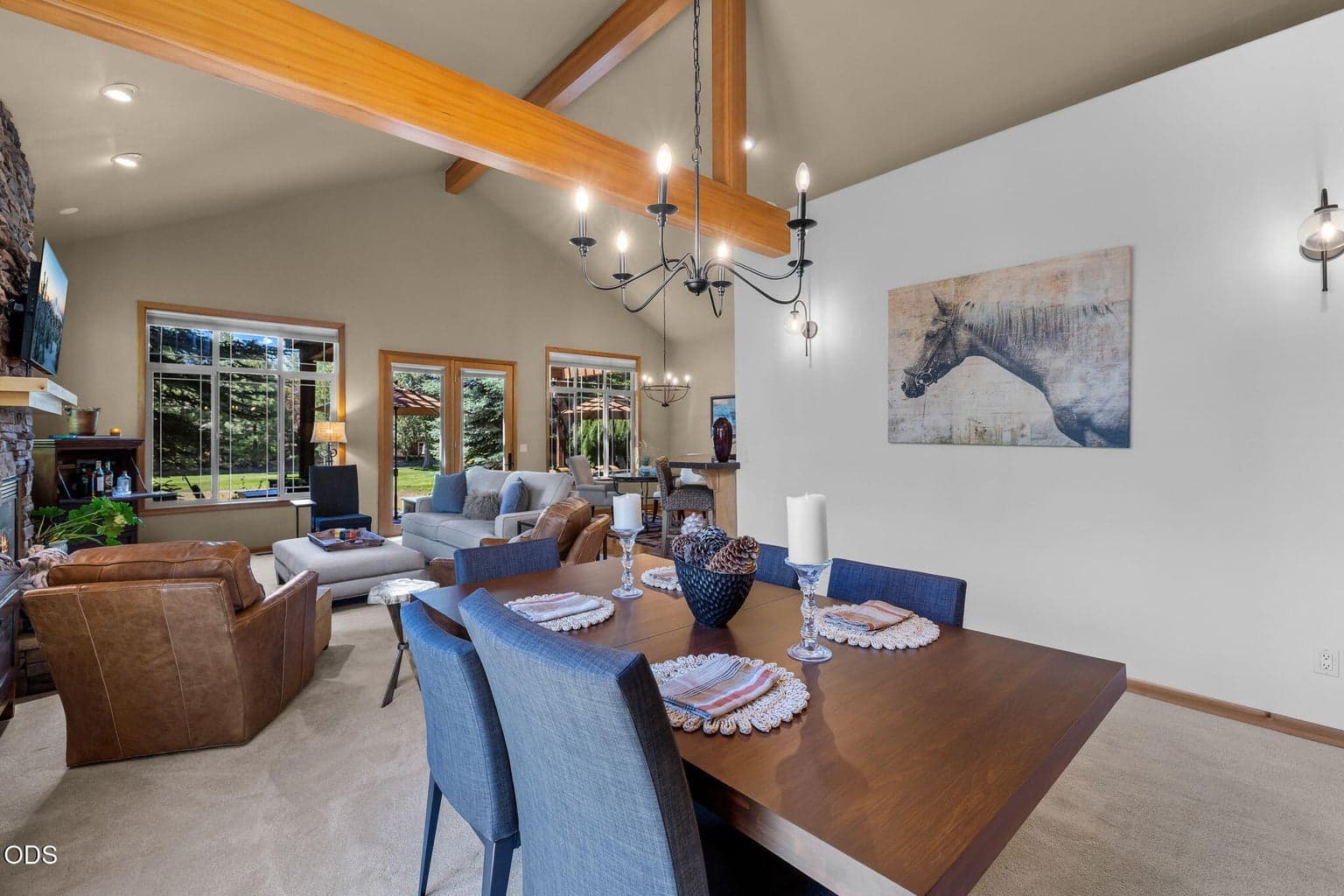 Beautiful stone fireplace anchors the great room, framed by large windows and warm wood accents.