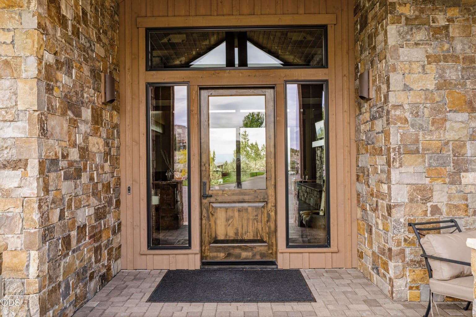 Welcoming covered front entrance with water feature to the left, statement stone and glass finishings