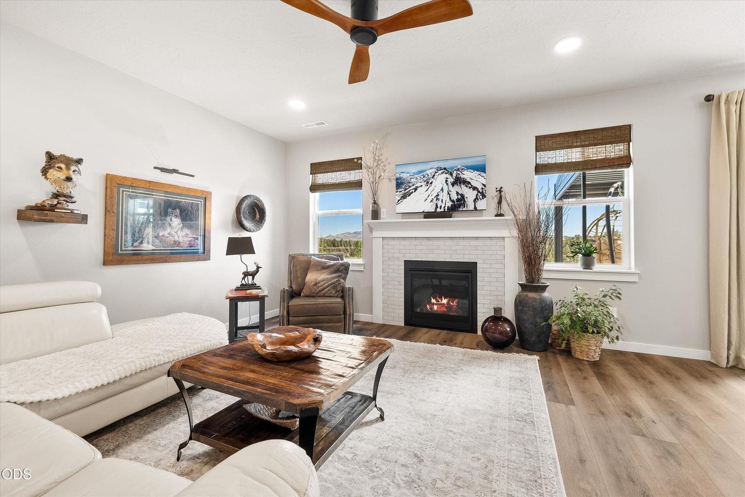 Windows flank the fireplace in living room.
