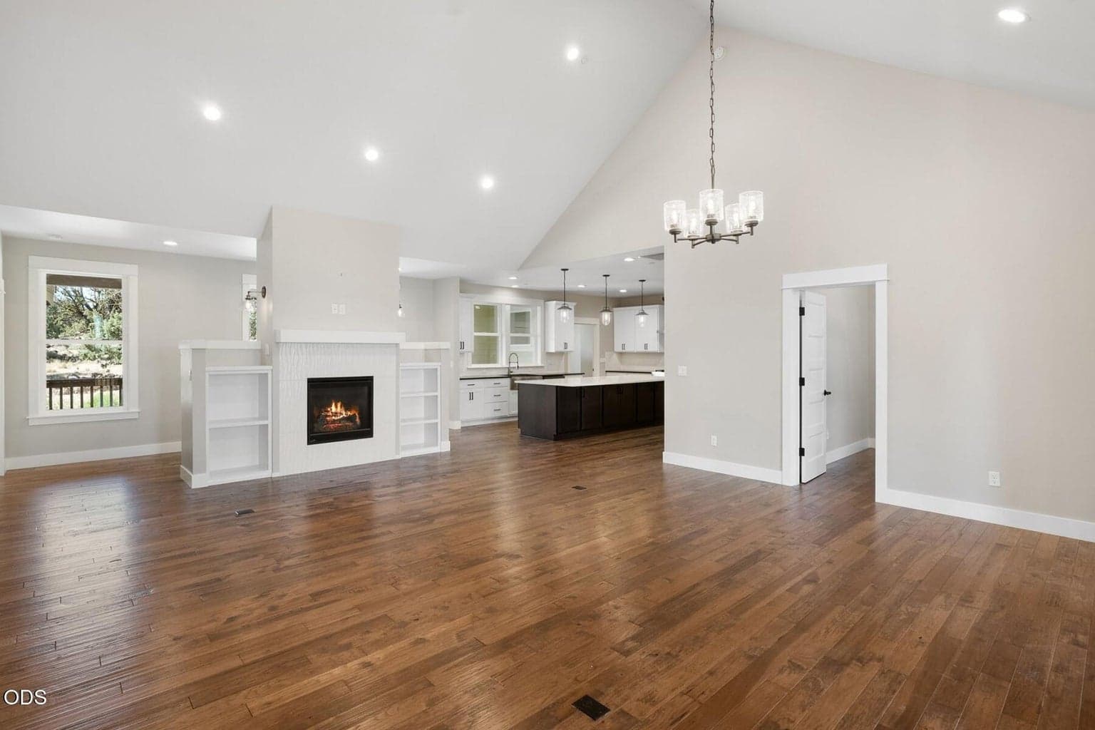 Open concept living with fireplace and vaulted ceiling.